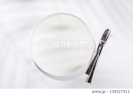 Empty plate on a white background with leaf shadows, perfect food mockup 130527911