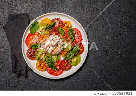 Fresh burrata served on slices of colorful tomatoes 130527921