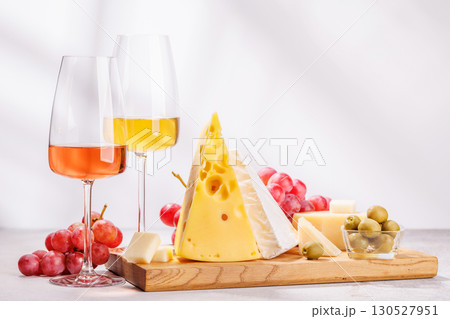 A delectable arrangement of various cheeses, fresh grapes, and wine 130527951