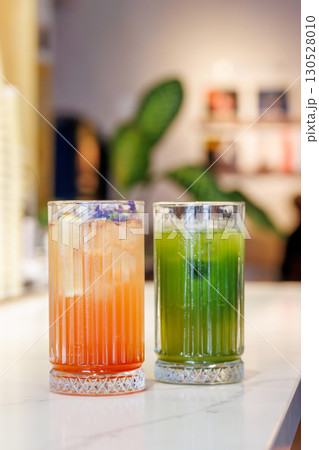 Assorted summer lemonades in glass jars with fresh fruits, ice, and garnishes 130528010