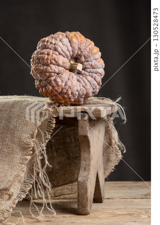 Black Futsu Mini Pumpkin On Rustic Wooden Stool Black Futsu Mini Pumpkin On Rustic Wooden Stool 130528473