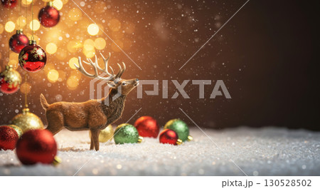 Christmas scene with a reindeer figurine in the snow, surrounded by ornaments and glowing bokeh lights. 130528502