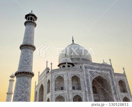 Taj Mahal in Agra, India. Spiritual white marble monument with intricate inlay, arches, dome, facade 130528651