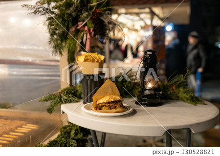 Delicious burgers on holiday street market in european city. Christmas street food festival on fair in town center, winter holidays 130528821