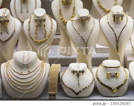 Golden necklace and earrings in a jewelry store. Luxury, wealth, and decorative fashion accessories. Golden necklace and earrings in a jewelry store. Luxury, wealth, and decorative fashion accessories. 130529297