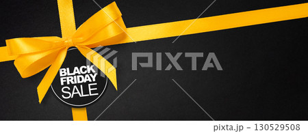 Advertising design for big Black Friday event with luxury ribbon and bold text. Suitable for banners, flyers and digital campaig Advertising design for big Black Friday event with luxury ribbon and bold text. Suitable for banners, flyers and digital campaig 130529508
