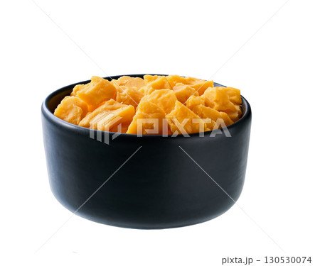 cheddar cheese pieces in black ceramic bowl isolated on white background. cheddar cheese pieces in black ceramic bowl isolated on white background. 130530074