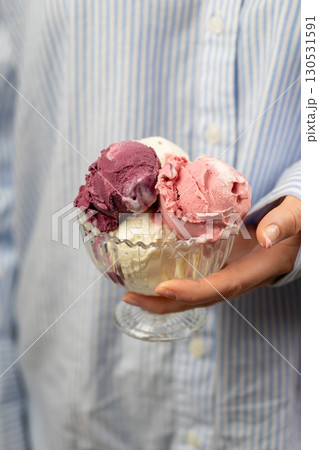 Colorful scoops of sorbet in glass bowl held by hand on white background Colorful scoops of sorbet in glass bowl held by hand on white background 130531591