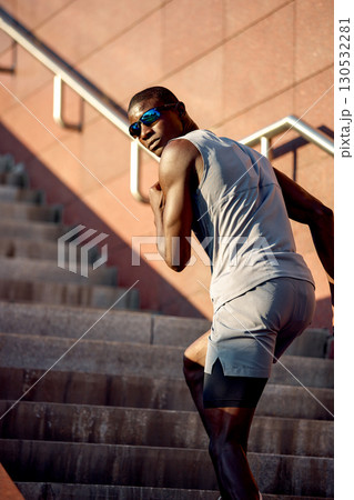 Athletic man jogging up stairs in outdoor urban environment on a sunny day 130532281
