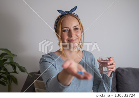 Middle age woman holding blue pills with fingers. Health care, dietary supplements, treatment of depression and diseases Middle age woman holding blue pills with fingers. Health care, dietary supplements, treatment of depression and diseases 130532724