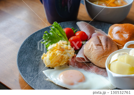 パンと卵、ハムとフルーツの洋朝食 130532761