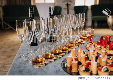 Elegant catering setup with gourmet canapes and whiskey in glasses for a corporate event Elegant catering setup with gourmet canapes and whiskey in glasses for a corporate event 130533415