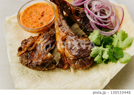 Grilled pork kebab with fresh herbs, red onion, lavash and spicy red pepper sauce Grilled pork kebab with fresh herbs, red onion, lavash and spicy red pepper sauce 130533448