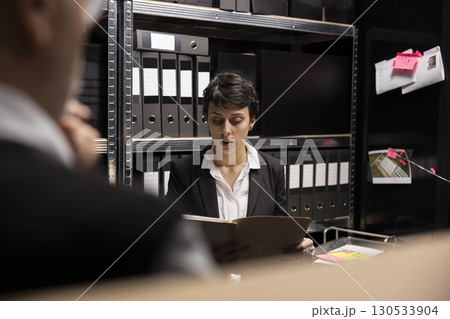 Detectives team conducting a private investigation with forensic evidence, working together to connect the dots and catch a criminal. Organizing confidential records in incident room. 130533904
