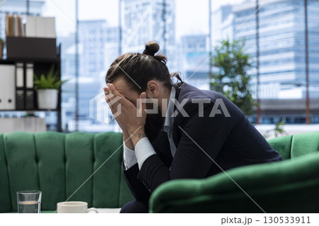 Male corporate leader buries his face in his hands due to frustration feeling the pressure of a declining economy and battling the stress of a failing company. Business downfall and bankruptcy. Male corporate leader buries his face in his hands due to frustration feeling the pressure of a declining economy and battling the stress of a failing company. Business downfall and bankruptcy. 130533911