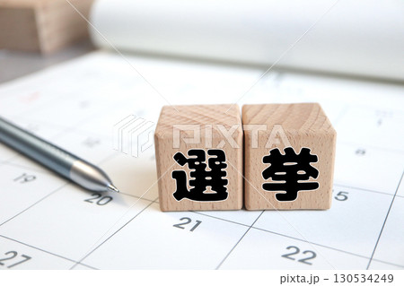 カレンダーの上に置かれた木製ブロックの選挙の文字。投票日程のイメージ。 130534249
