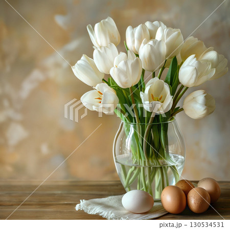 Glass Vase pristine white bouquet tulips elegantly stands amidst scattered Easter eggs, combining freshness spring blooms with joy of holiday. soft backdrop. Holidays spring Easter concept, copy space 130534531