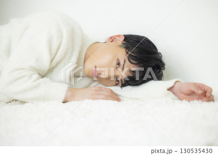 寝転がるニットの男性　 130535430