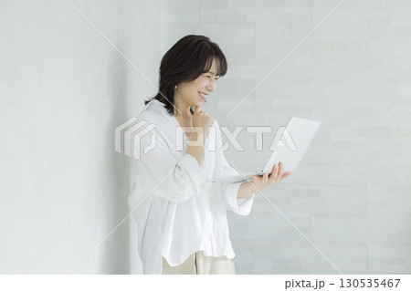 ノートパソコンを持つ笑顔の女性 130535467