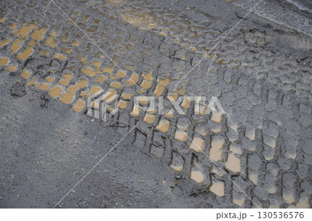 タイヤの跡がついた泥道 130536576