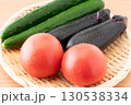 竹ざるに載せた瑞々しいトマトとナスと胡瓜（夏野菜）のクローズアップ 130538334
