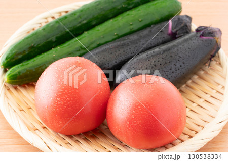 竹ざるに載せた瑞々しいトマトとナスと胡瓜(夏野菜)のクローズアップ 竹ざるに載せた瑞々しいトマトとナスと胡瓜(夏野菜)のクローズアップ 130538334
