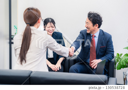 笑顔で握手を交わす3人のビジネスパーソン 130538728