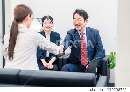 笑顔で握手を交わす3人のビジネスパーソン 笑顔で握手を交わす3人のビジネスパーソン 130538732