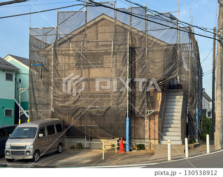 アパートの外壁塗装のための足場と黒いネット 130538912