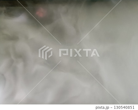 Thick white smoke rising, creating mysterious and foggy atmosphere, with hint of pink light in background, evoking sense of intrigue and calmness Thick white smoke rising, creating mysterious and foggy atmosphere, with hint of pink light in background, evoking sense of intrigue and calmness 130540851