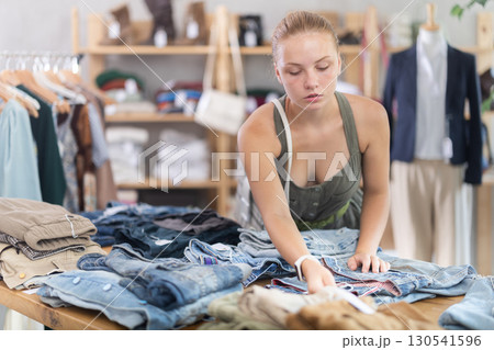 Teenage girl choosing pantaloons in clothing store Teenage girl choosing pantaloons in clothing store 130541596