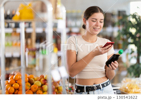 Young woman scanning qr code of soy sauce 130541622
