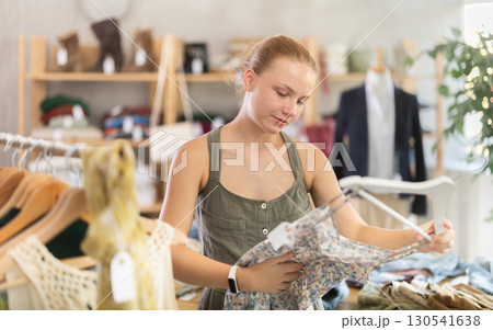Teenage girl choosing something for summer in clothing store 130541638
