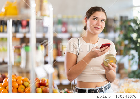 Young woman scanning qr code of canned food 130541676