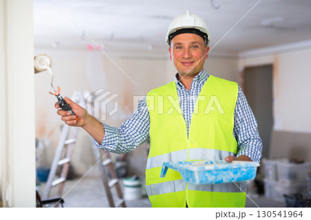 Positive builder painting wall in apartment Positive builder painting wall in apartment 130541964