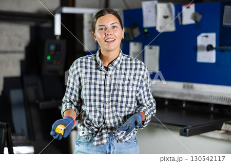 Portrait of positive female worker in workshop of metallurgical plant Portrait of positive female worker in workshop of metallurgical plant 130542117