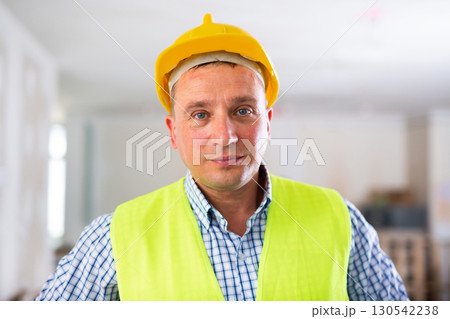 Waist-up portrait of man builder in coverall and helmet Waist-up portrait of man builder in coverall and helmet 130542238