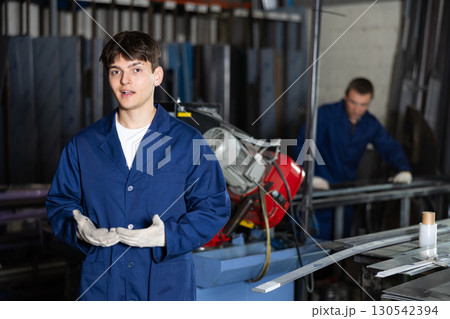 Young guy posing in metallurgical workshop Young guy posing in metallurgical workshop 130542394