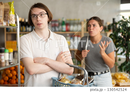 Young woman quarrels with man in grocery store 130542524
