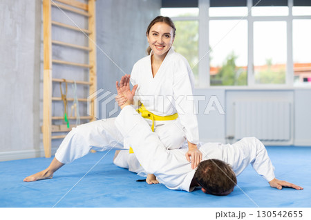 Adult man and young woman training judo fight Adult man and young woman training judo fight 130542655