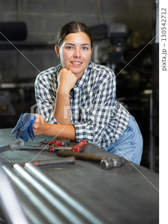 Young woman posing in metallurgical workshop Young woman posing in metallurgical workshop 130542712