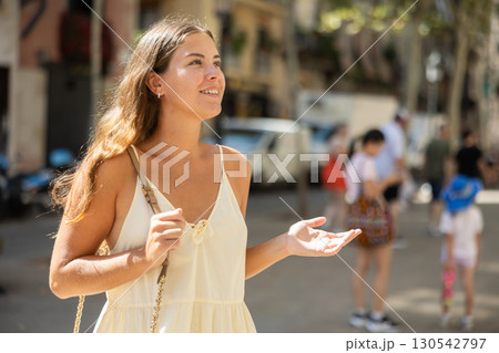 Portrait of a young girl in a light summer dress on city street during the day Portrait of a young girl in a light summer dress on city street during the day 130542797