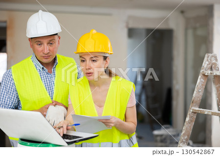 Woman architect and man engineer using laptop in construction site Woman architect and man engineer using laptop in construction site 130542867
