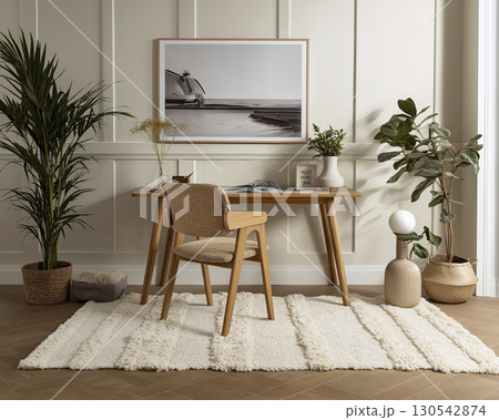 Minimalist home office with wooden desk and chair, surrounded by potted plants and modern decor, creates cozy and stylish workspace 130542874