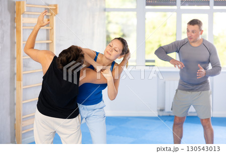 Woman makes a choke hold in self defense trainin 130543013