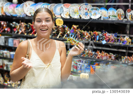 Barcelona souvenir shop - happy girl chooses bull figurine 130543039