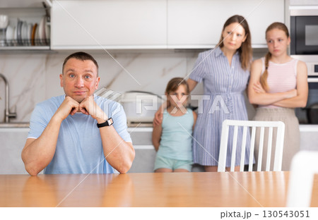 Wife and children stand behind dad and are afraid to ask about current problem 130543051