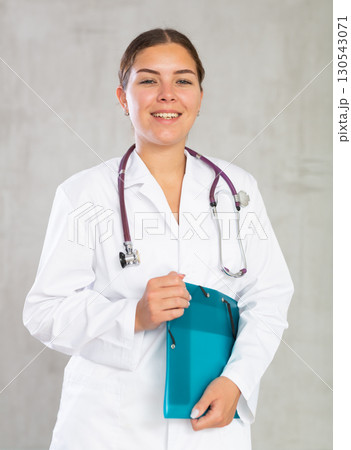 Young woman posing in medical uniform with folder Young woman posing in medical uniform with folder 130543071