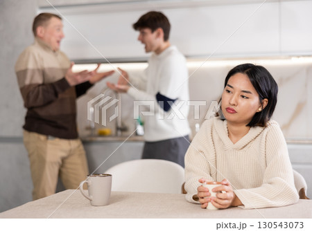 Young girl is tired of domestic quarrels. Relatives quarreling in background 130543073