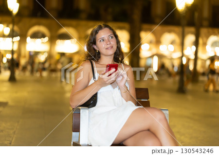 Woman sitting on a chair on a Barcelona street 130543246